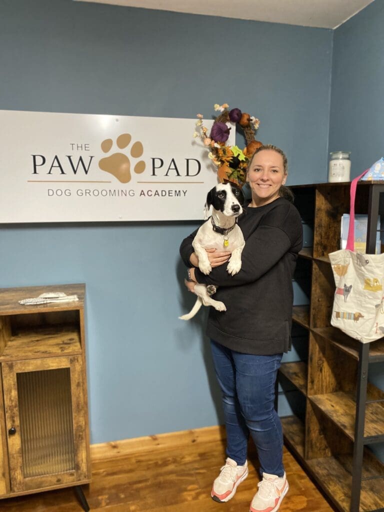 amy cuddling dog with the pawpad logo behind
